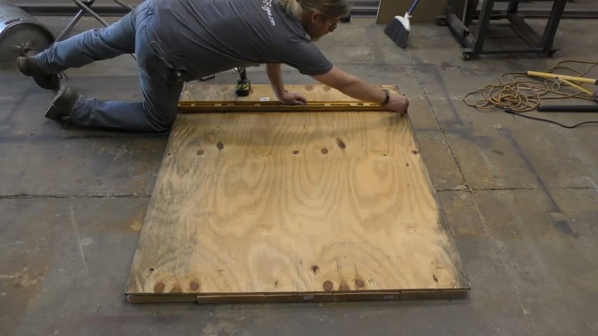 Fijando el plywood encima del panel con tornillos