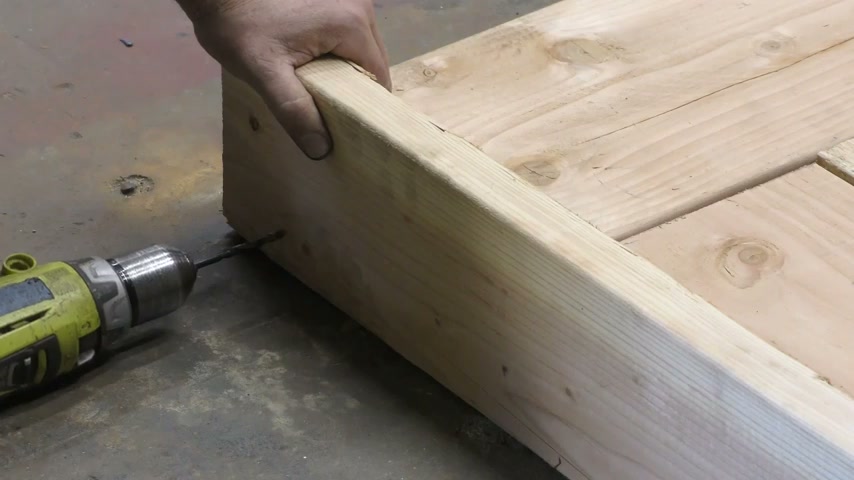 Atornillando el poste 2x6 al costado del panel con taladro